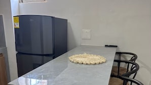 Une cuisine dotée d’un plan de travail en marbre gris, d’un réfrigérateur noir et d’une fenêtre offrant une vue agréable.