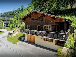Un chalet en bois doté d’un balcon, d’une porte et d’une fenêtre.