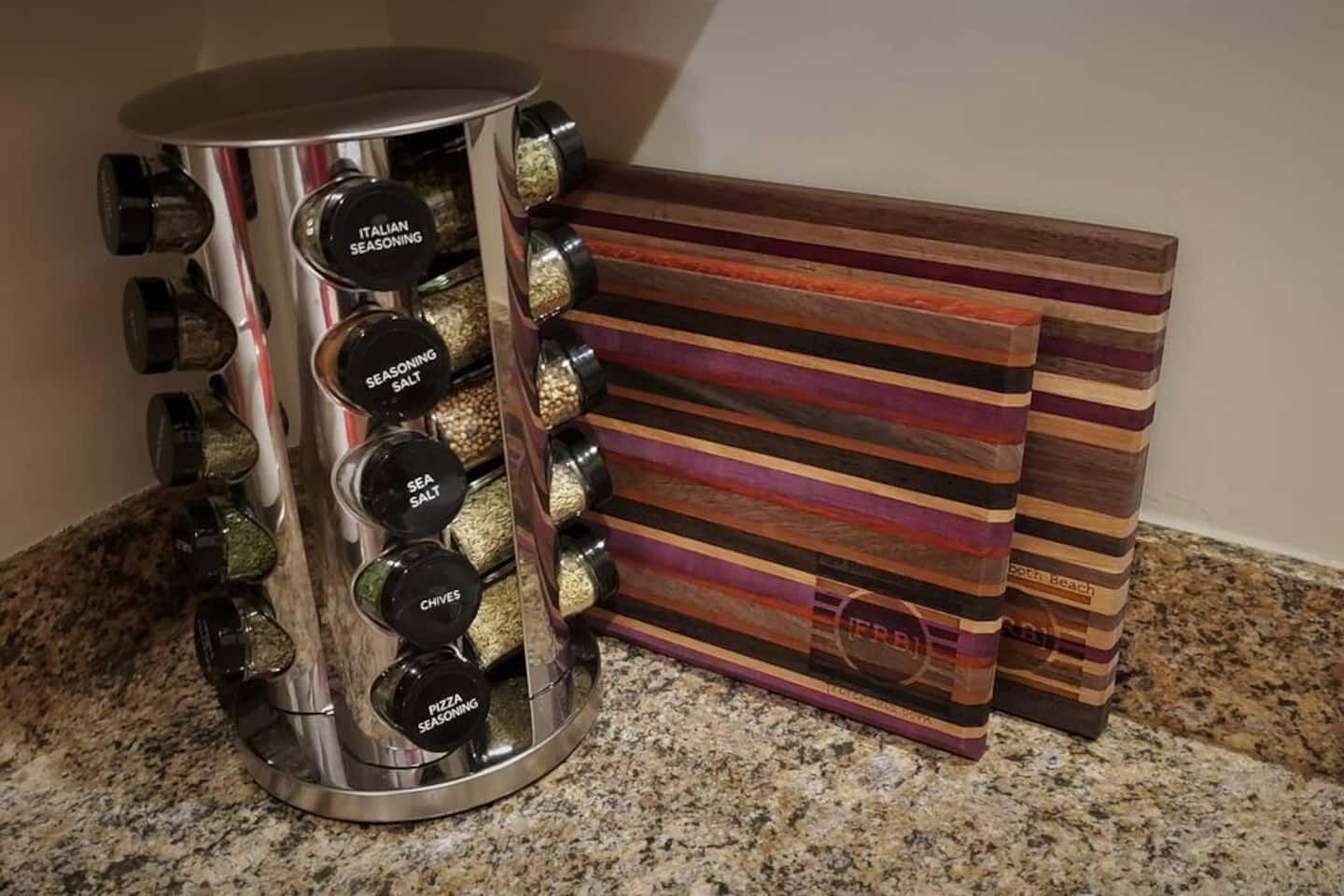 Un organizador de especias con recipientes etiquetados y un juego de posavasos a rayas.