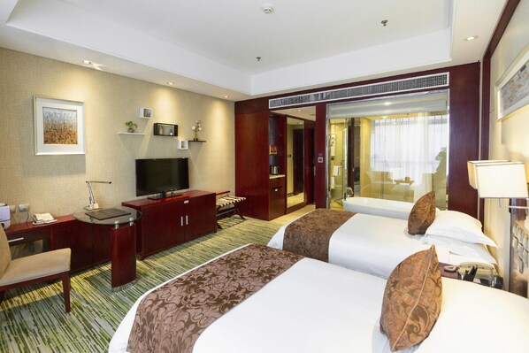 A hotel room with a bed, a desk, a television, a wardrobe, and a bathroom visible through an open door. - Pidu International Hotel (Xinji)
