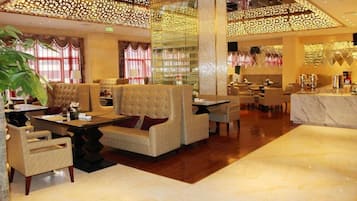 A spacious lobby with a high ceiling, comfortable seating, and a bar area.