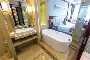 Un baño moderno con una bañera grande, un tocador con espejo y una zona de ducha.