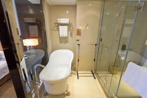 A modern bathroom with a freestanding bathtub, a glass-enclosed shower, and a visible towel rack.