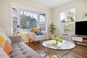 Relax in this stylish living room with a comfortable sofa, flat-screen TV, and a cozy coffee table.