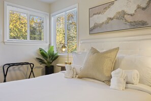 Relax in this inviting room with a comfortable bed, a cozy reading nook, and a touch of greenery.