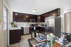 Enjoy cooking in this well-equipped kitchen with a central island, sink, and dining area.