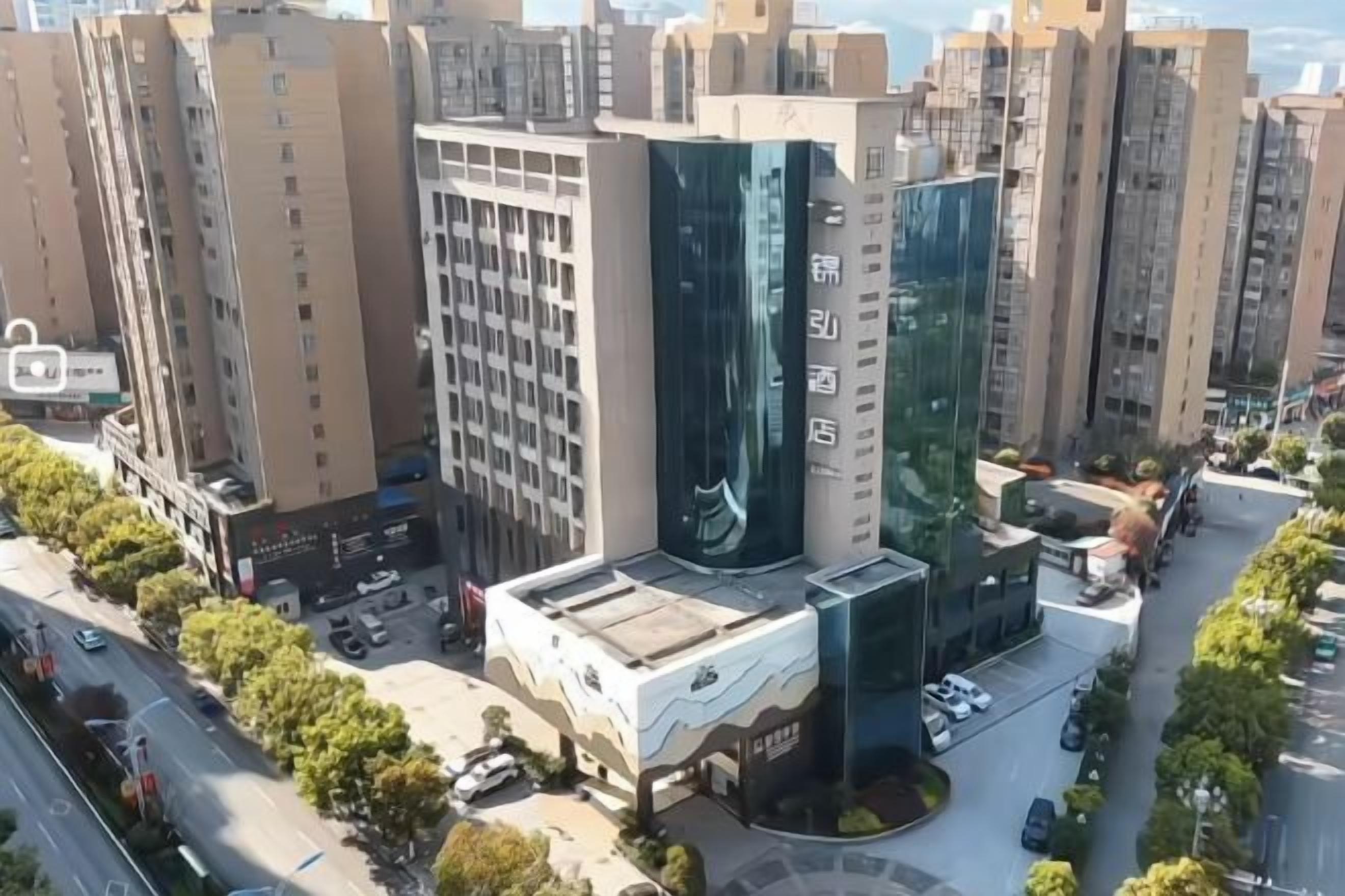 Un edificio de gran altura con fachada moderna de vidrio, rodeado de otros edificios altos.