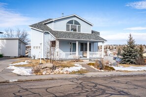 A two-story house with a front porch, a garage, and a driveway.