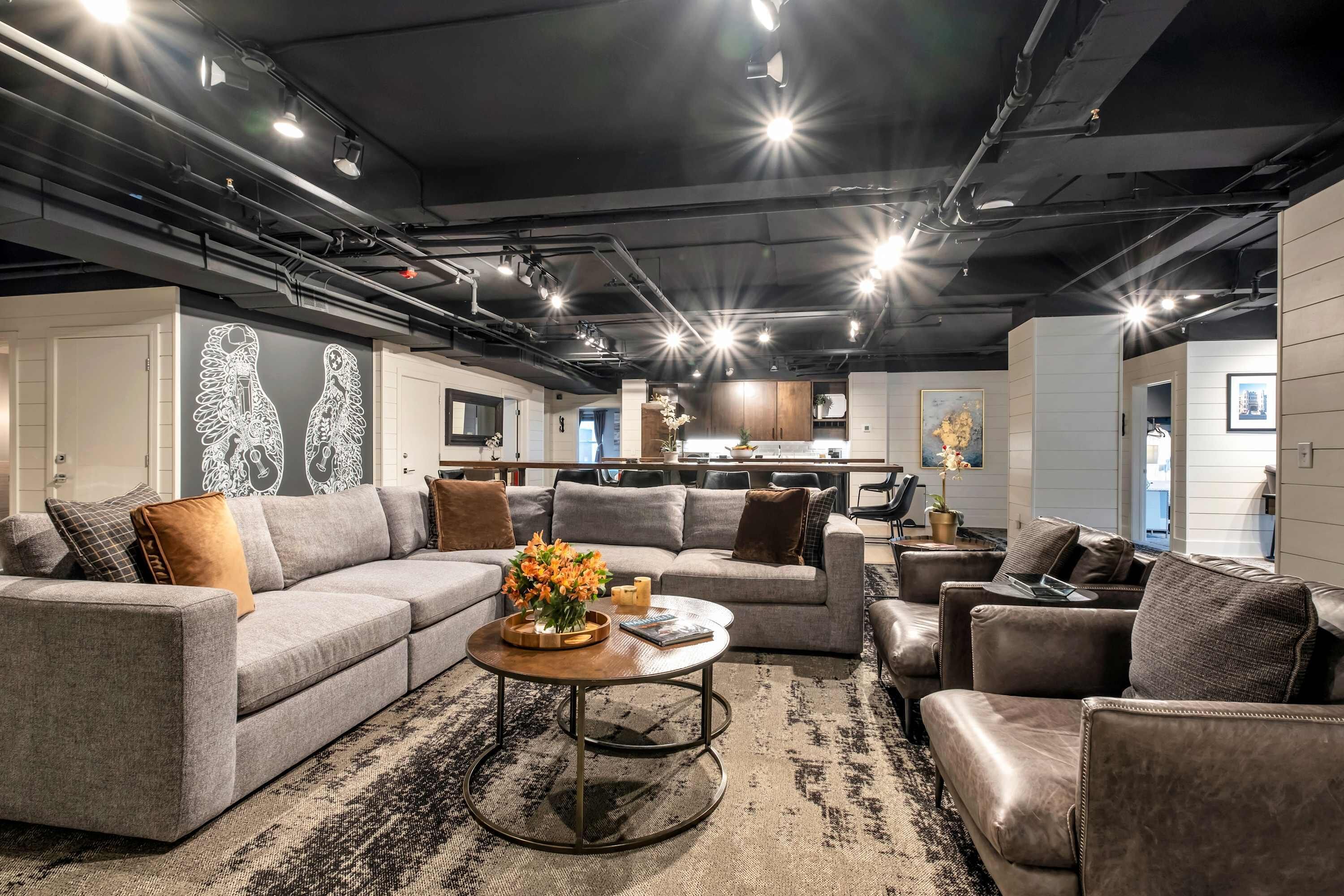 A modern living room with a sectional sofa, a coffee table, and a patterned rug.