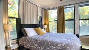 Ein Schlafzimmer mit Bett, Nachttisch, Lampe und Deckenventilator.