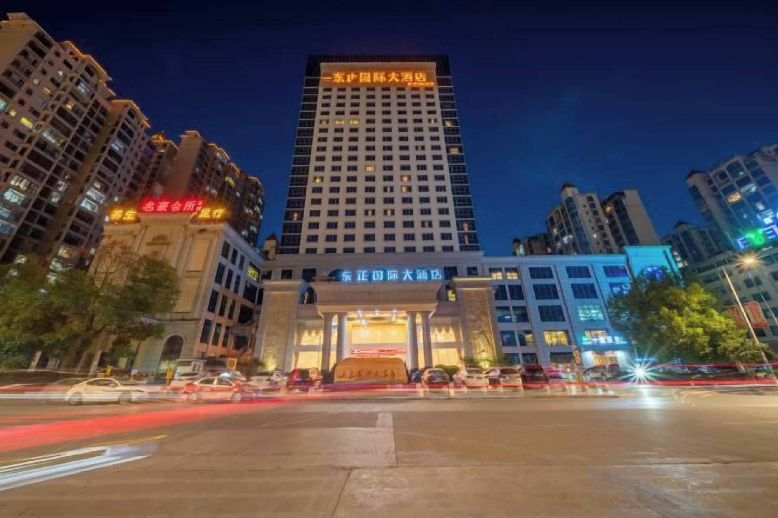 Un hotel de varios pisos con una entrada destacada y señalización.