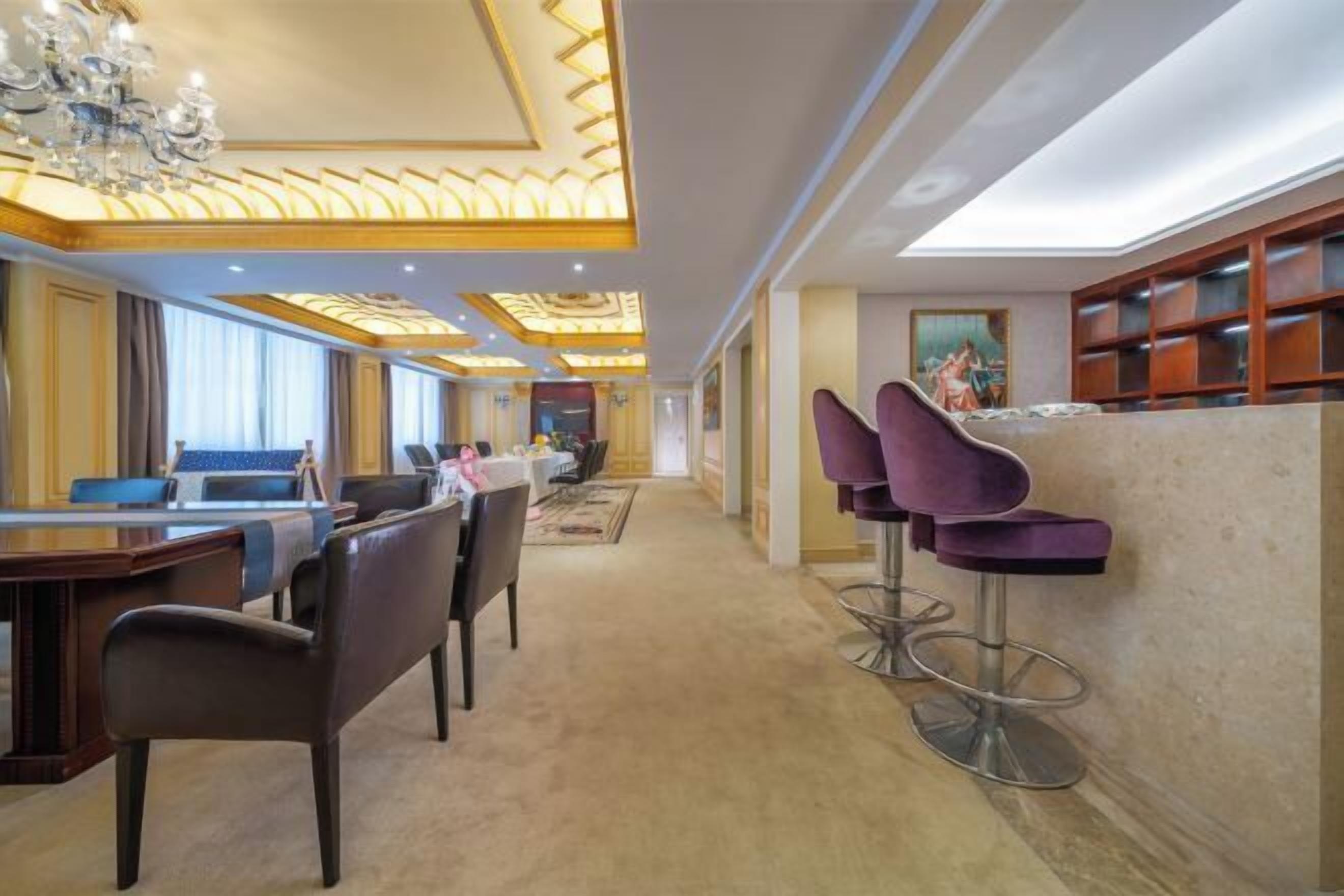 A hotel lobby with a reception desk, bar area, and seating.