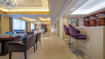 A hotel lobby with a reception desk, bar area, and seating.