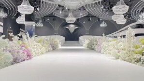 A grand hall with a central staircase, chandeliers, and floral arrangements. - Dong Zheng International Hotel (Hechi)
