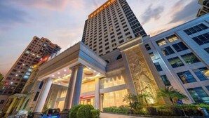 A modern hotel with a prominent entrance, large columns, and a well-lit facade. - Dong Zheng International Hotel (Hechi)