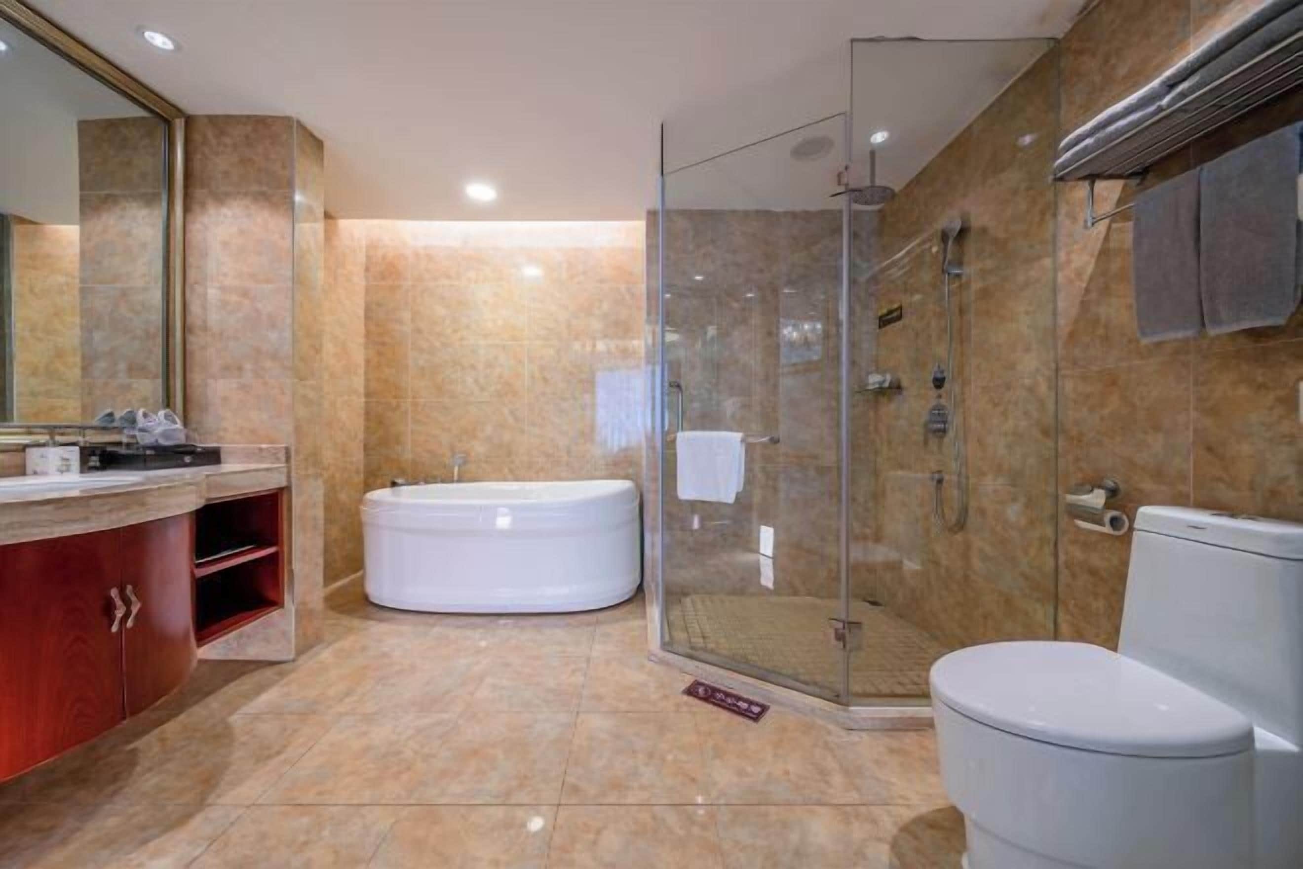 A modern bathroom with a glass-enclosed shower, a freestanding bathtub, and a toilet.