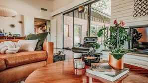 Een moderne woonkamer met een leren bank, een salontafel en een potplant.