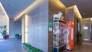 A modern lobby with a vending machine, a glass display case, and a small plant arrangement. - Jinjiang Inn (Ulanqab Jining Railway Station Xingfu Road) (Ulanqab)