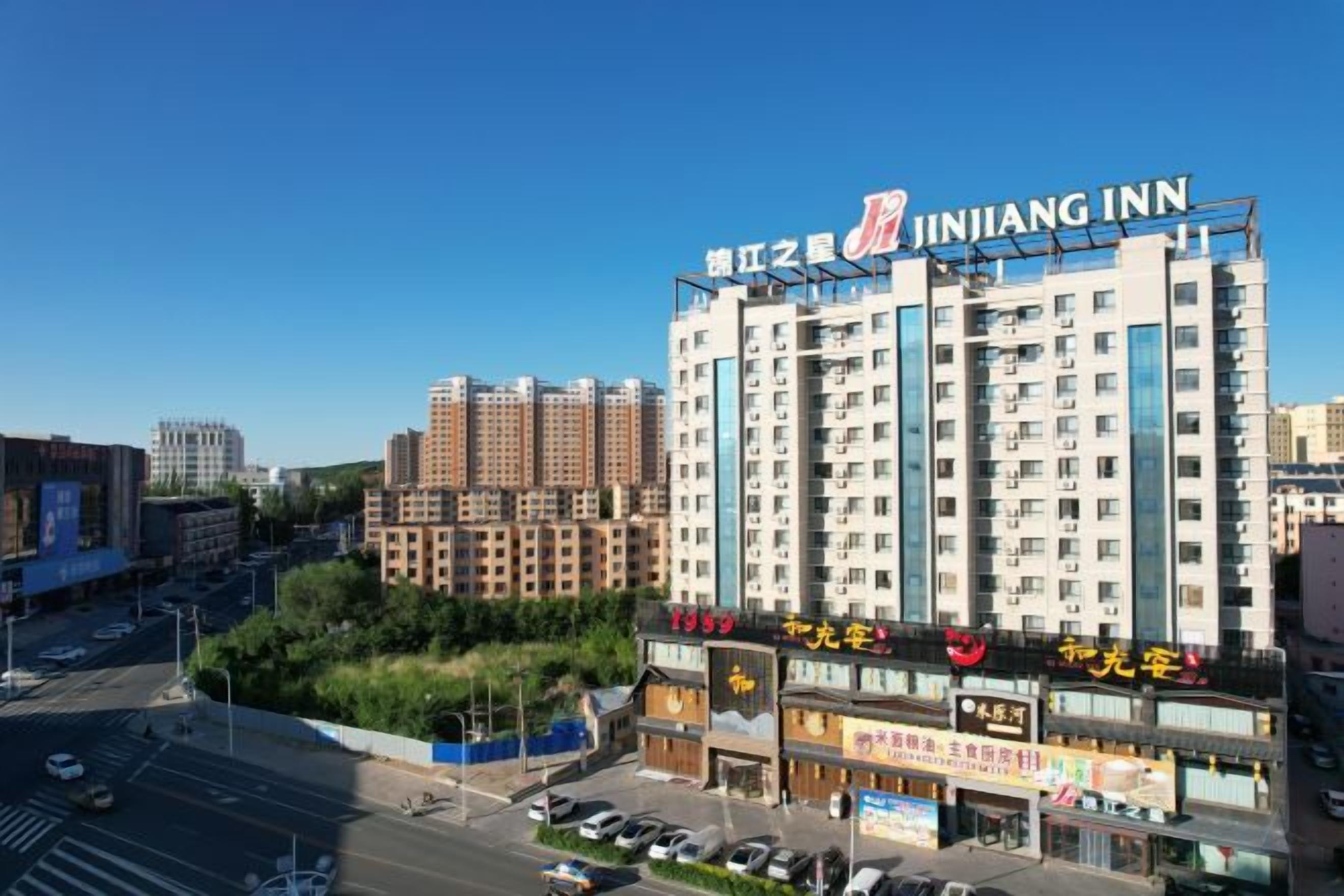 Un hotel de varios pisos con un letrero llamativo que dice 'JINJIANG INN' en la parte superior.