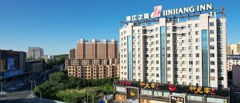 Un hotel de varios pisos con un letrero llamativo que dice 'JINJIANG INN' en la parte superior.