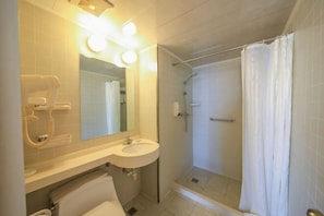 Ein Badezimmer mit Waschbecken, Spiegel und Dusche.