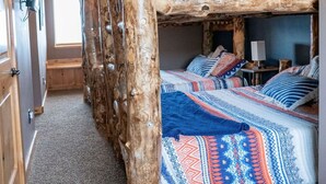 A room with a bunk bed, a ceiling fan, and a window providing natural light. - Lake Vista Lodge | 5BR Sleeps 24 | Stunning Lake Views, Direct ATV & Snowmobile Trail Access (Garden City)