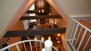 A multi-level interior with a staircase, wooden beams, and a chandelier. - Peek' n Peak, Camelot  Loft Condo,  Clymer, NY, 250 Yards to Chair 8, Sleeps 14 (Clymer)
