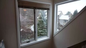 A room with a window overlooking a snowy landscape and a neighboring building. - Peek' n Peak, Camelot  Loft Condo,  Clymer, NY, 250 Yards to Chair 8, Sleeps 14 (Clymer)