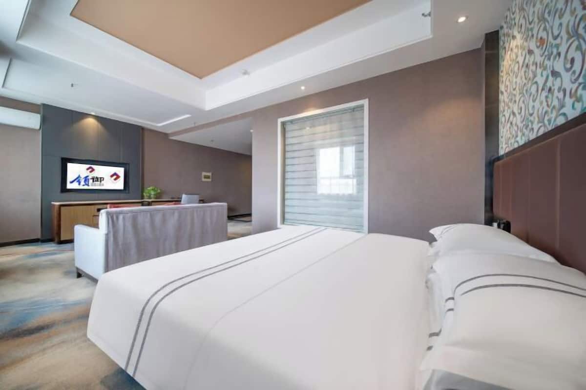 Ein Hotelzimmer mit einem großen Bett, einem Schreibtisch und einem Fernseher.