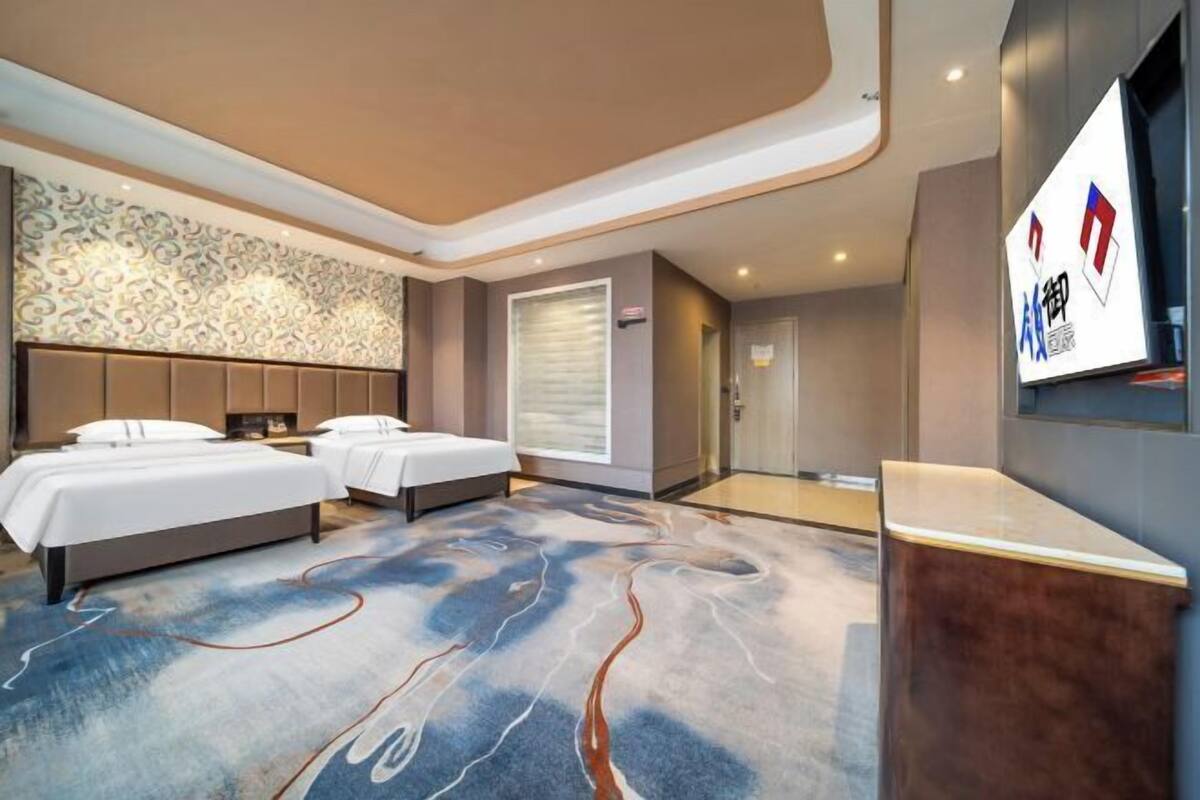 Ein Hotelzimmer mit zwei Betten, einem großen Spiegel und einer Rezeption.
