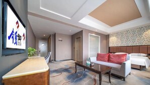 A hotel lobby with a reception desk, a sofa with red cushions, a patterned carpet, and a decorative wall. - Lingyu International Boutique Hotel (Jinghe)