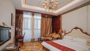Una habitación de hotel con una cama grande, televisión, escritorio y silla.
