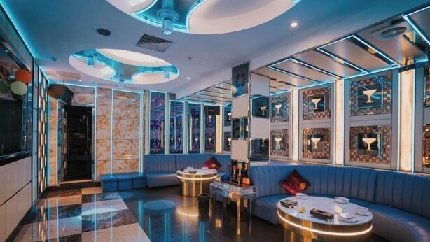 Un área de lounge moderna con asientos, piso pulido e iluminación decorativa.