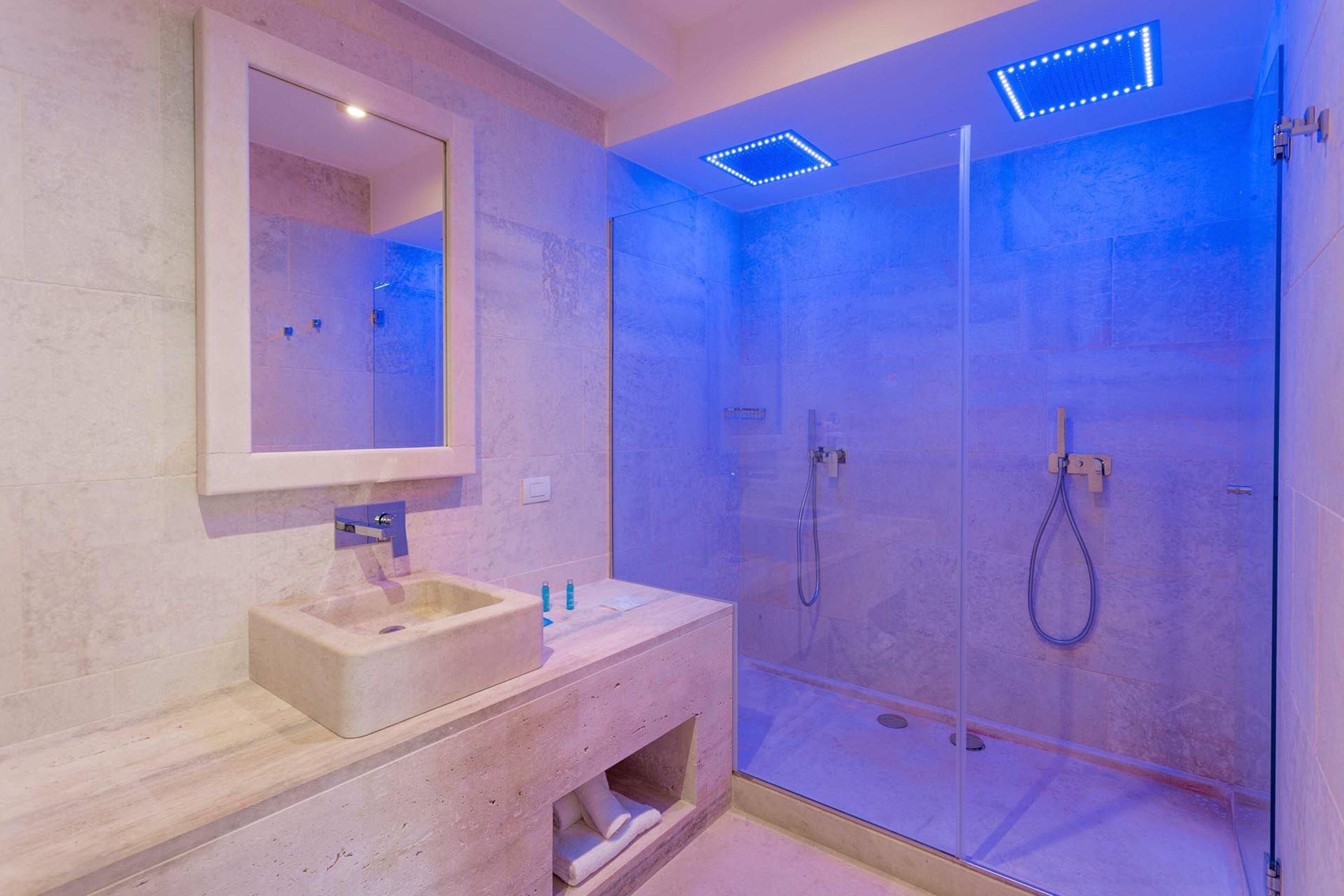 Een moderne badkamer met een douchecabine, een ingebouwd wastafelmeubel en een spiegel erboven.
