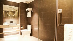 Un baño moderno con cabina de ducha de vidrio, inodoro y lavamanos.