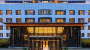 A modern hotel with a traditional architectural element on the top. It features a large glass entrance with a reception desk. - Botai Hotel (Yongqing)