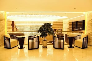 A lobby with a central seating area, a large chandelier, and a television screen on the wall. - Botai Hotel (Yongqing)