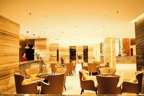 A spacious lobby with marble walls, multiple seating areas, and a reception desk. - Botai Hotel (Yongqing)
