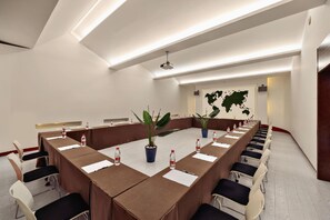 A conference room with a long table, chairs, water bottles, and potted plants. - Botai Hotel (Yongqing)