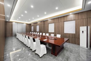 A conference room with a long table, white chairs, and a whiteboard on the wall. - Botai Hotel (Yongqing)