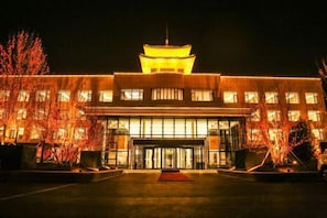 A building with a traditional pagoda-style roof, large glass entrance, and a well-lit facade. - Botai Hotel (Yongqing)