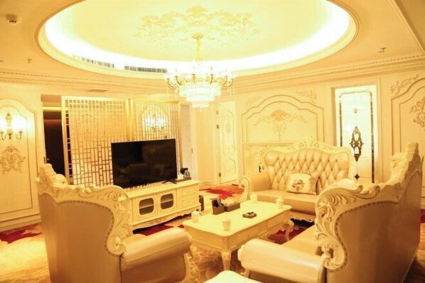 A luxurious living room with a large television, ornate white furniture, and a chandelier. - Botai Hotel (Yongqing)