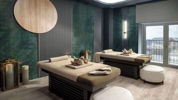 Relax in a serene spa room with a massage table, decorative stones, and a city view.