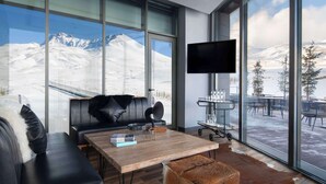 A modern living room with a large window overlooking a snowy mountain landscape. - Radisson Blu Hotel, Mount Erciyes (Kayseri)