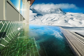 A clear view of a swimming pool with a mountain landscape in the background.