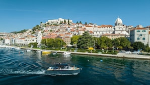 A coastal town with historic buildings, a prominent church, and a marina with boats. - Armerun Heritage Hotel (Sibenik)