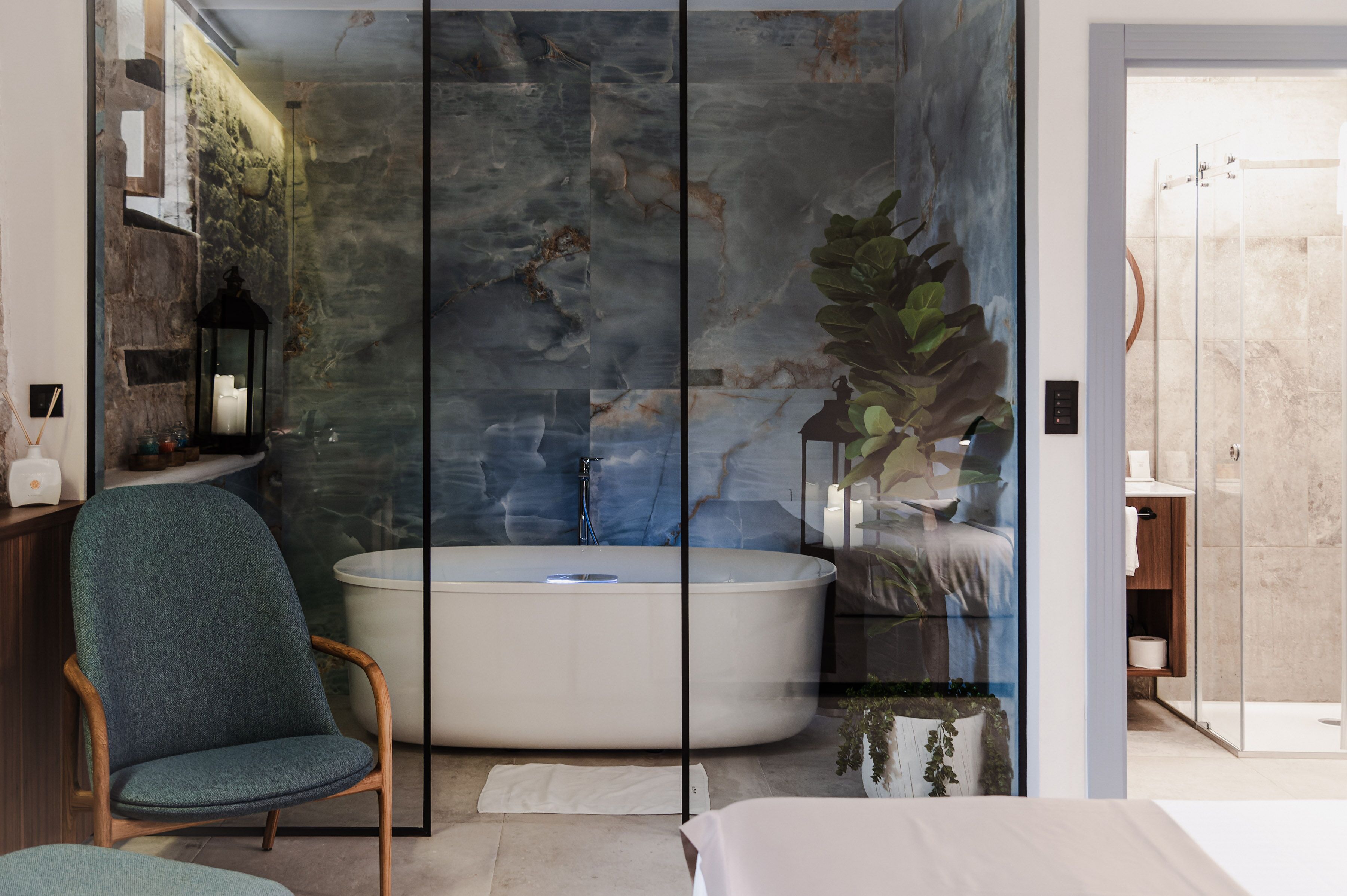 Une salle de bain moderne avec une baignoire sur pieds, une douche à parois de verre et une grande plante en pot.