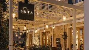 An outdoor seating area of a restaurant with hanging lights and a sign that reads "Buit A Restaurant". - Armerun Heritage Hotel (Sibenik)