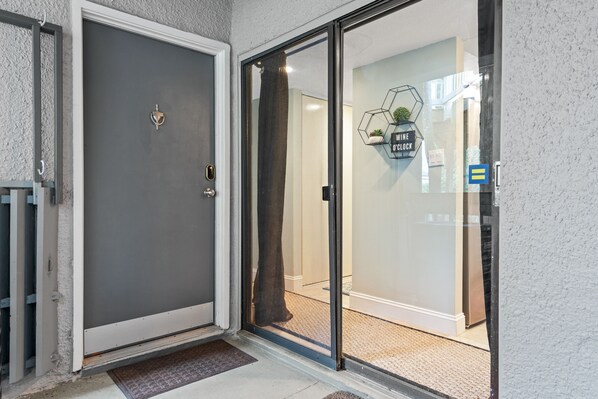 A modern entrance with a grey door and a glass door leading inside. - Spacious Family or Couples Condo - Walk to Coligny Beach & Shops (Hilton Head Island)
