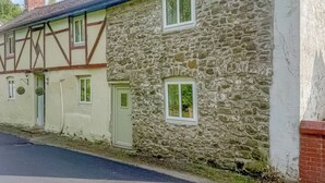 Ein traditionelles Steinhaus mit einem Satteldach, mehreren Fenstern und einem Schornstein.
